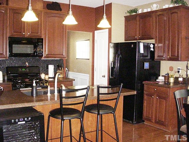 3809 Cathedral Bell Road Raleigh, NC 27614 - Photo 8 of 25 a kitchen with granite countertop a refrigerator stove and microwave