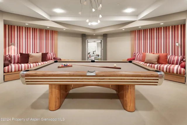 a room with pool table and windows