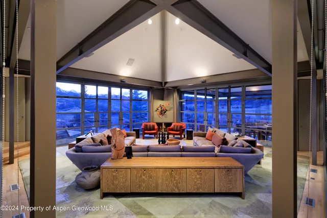 a living room with furniture fireplace and a large window