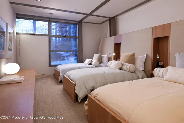 a bedroom with two beds and a chandelier