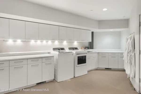 a kitchen with white cabinets and white appliances