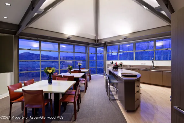 a kitchen with a table chairs and a wooden floor