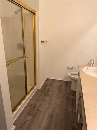 a bathroom with a granite countertop toilet and a shower