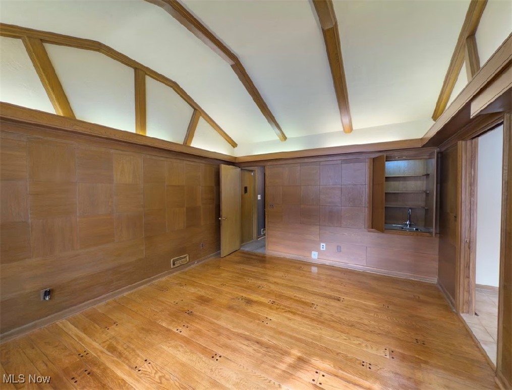 7817 Montello Road Independence, OH 44131 - Photo 5 of 35 Unfurnished room with lofted ceiling with beams and light wood-type flooring