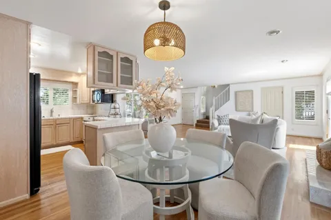 a dining room with furniture a chandelier and wooden floor
