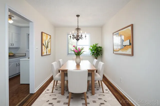 a view of a dining room with furniture a chandelier and wooden floor