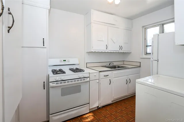 a view of washer and dryer with kitchen in the background