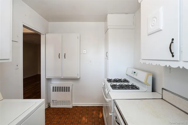 a kitchen with cabinets and stove top oven