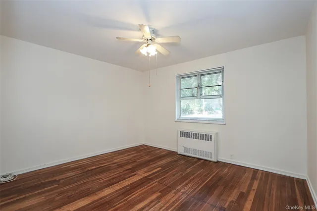a view of a room with wooden floor and fan