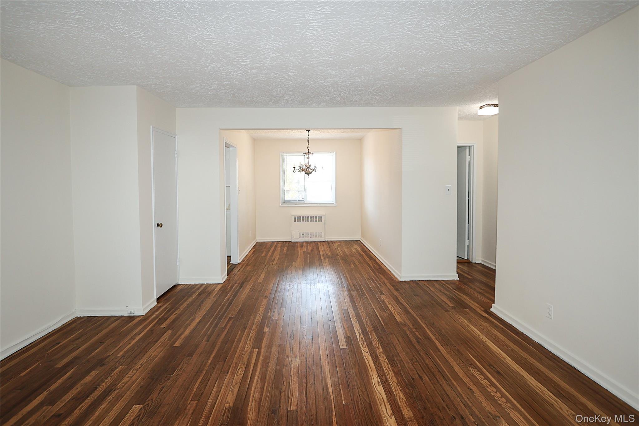 220-04 Stronghurst Avenue, Unit 185 Queens, NY 11427 - Photo 6 of 33 wooden floor in a hall with an entryway