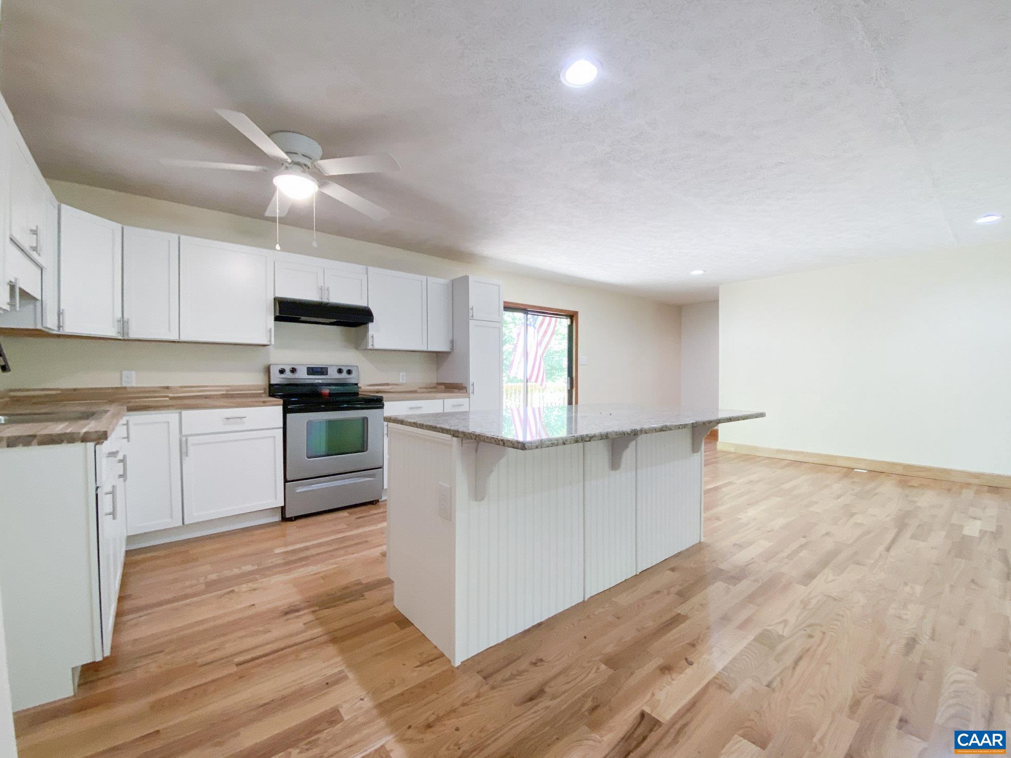 247 Goldenrod Road Ruckersville, VA 22968 - Photo 7 of 35 a kitchen with granite countertop white cabinets and white appliances