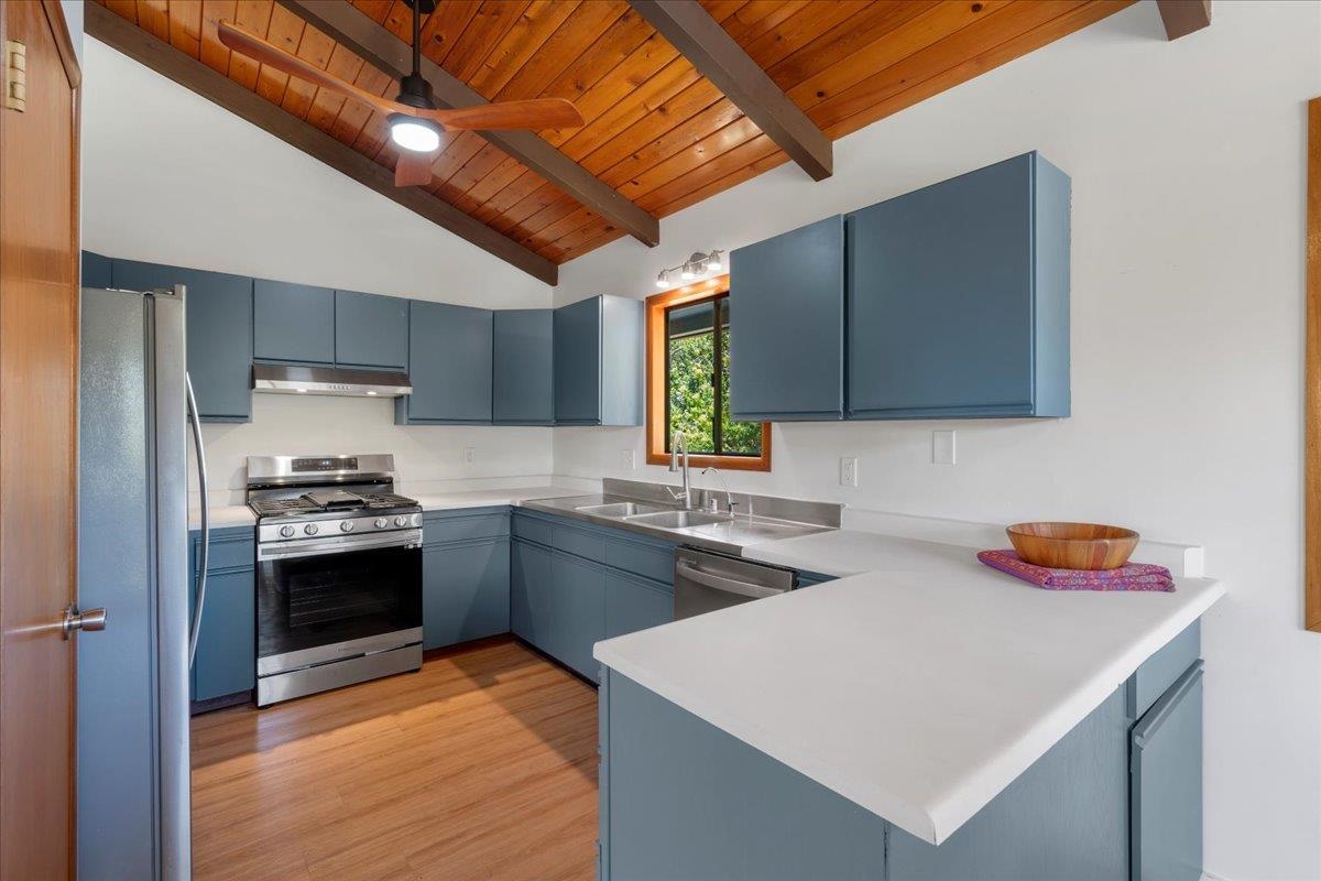 2130 Kauhikoa Road, Unit A Haiku, HI 96708 - Photo 5 of 43 a kitchen with stainless steel appliances granite countertop a sink a stove and a refrigerator