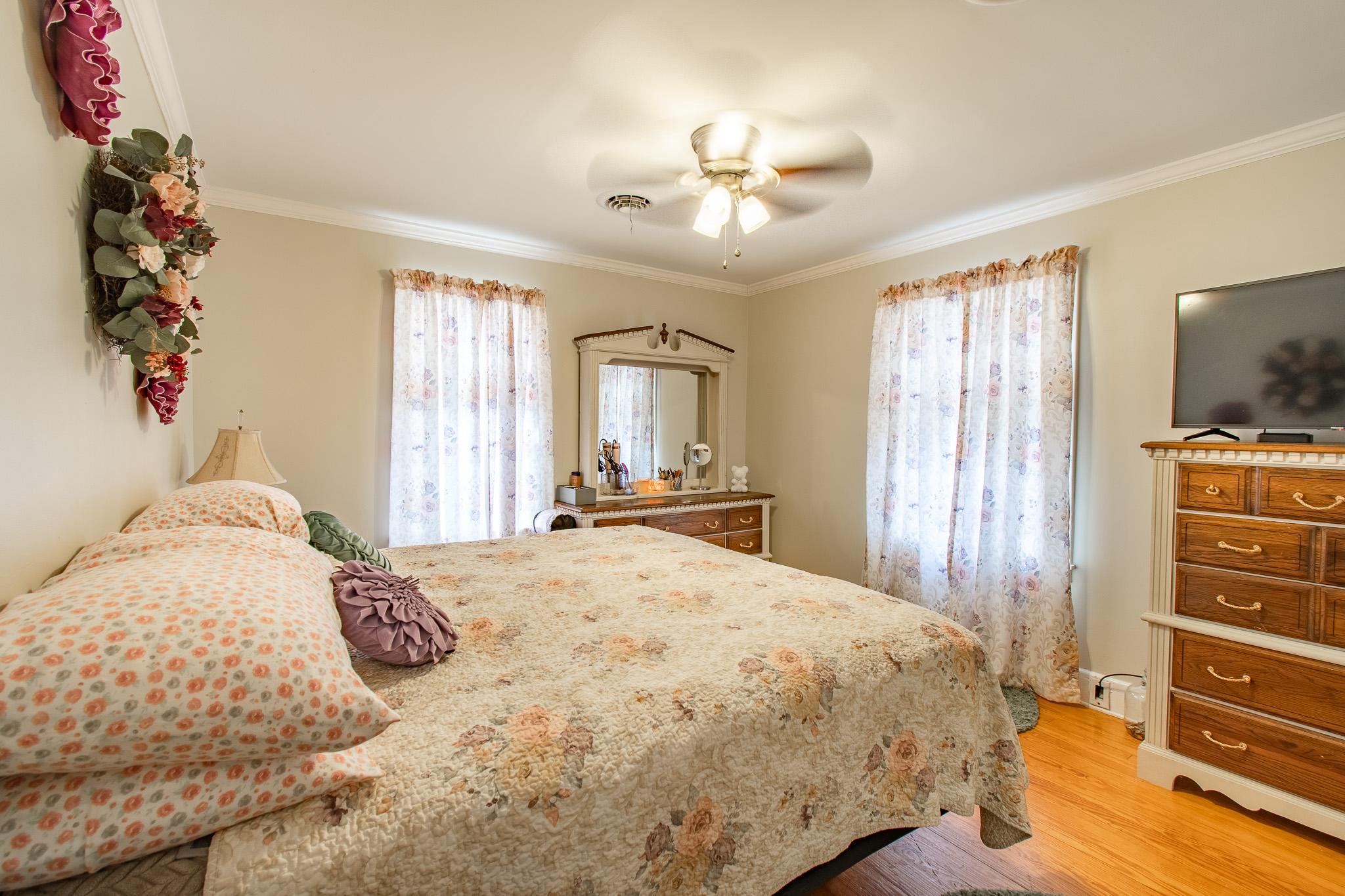 9 Oak Street Cambridge, MD 21613 - Photo 12 of 29 a bedroom with a bed and a chandelier