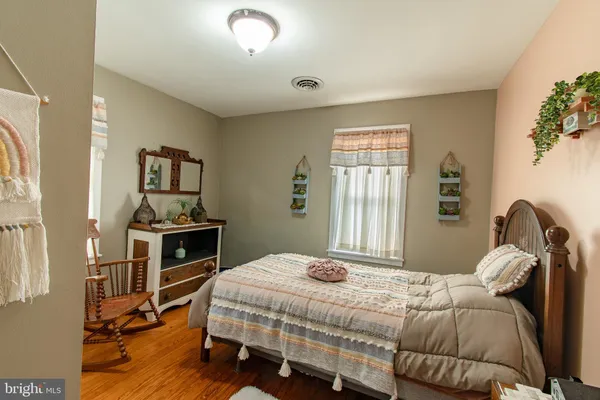 a bedroom with a bed wooden floor and a flat tv screen