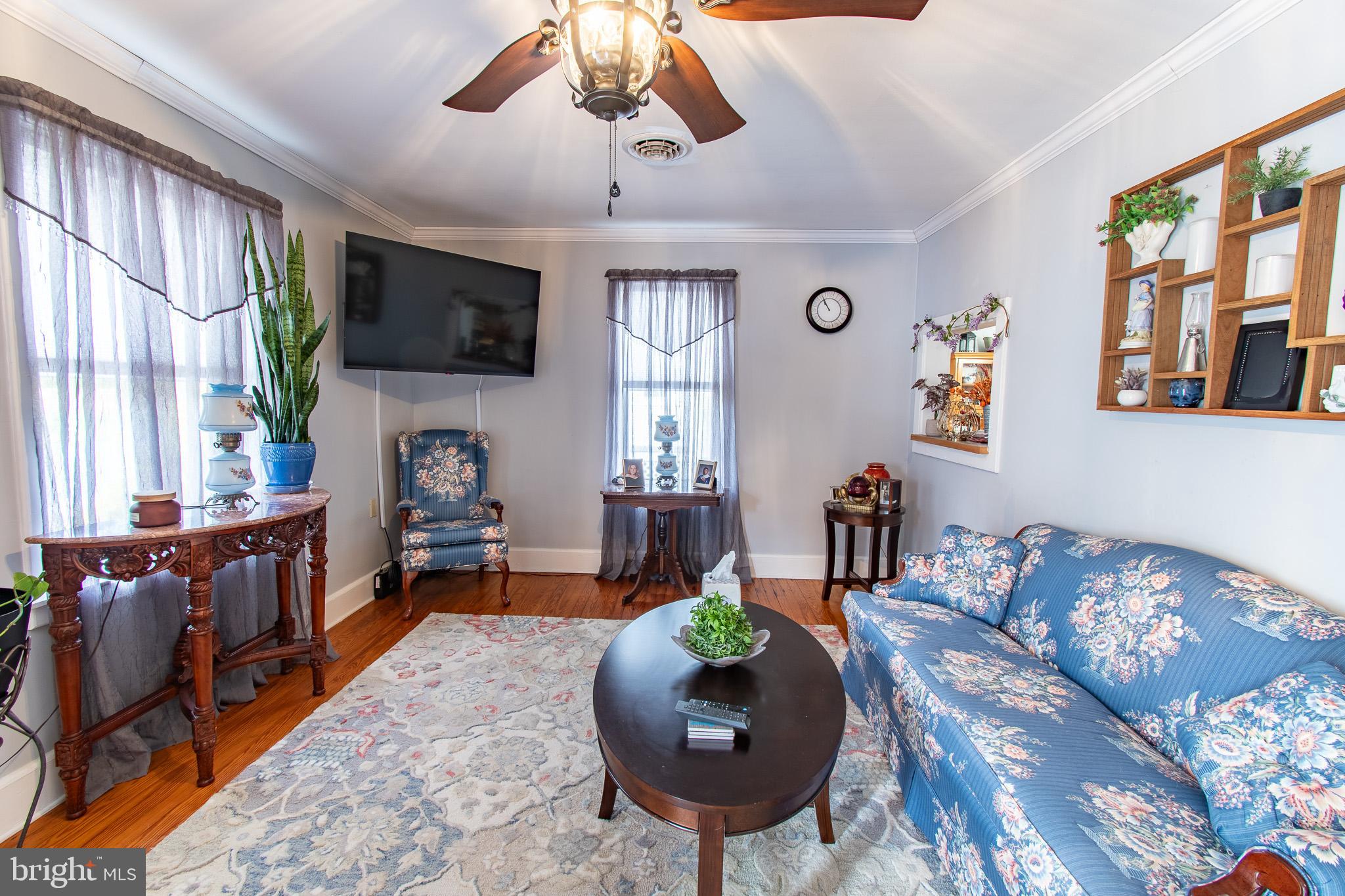 9 Oak Street Cambridge, MD 21613 - Photo 3 of 29 a living room with furniture a flat screen tv and a large window