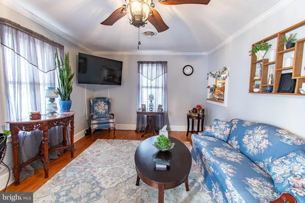 a living room with furniture a flat screen tv and a large window