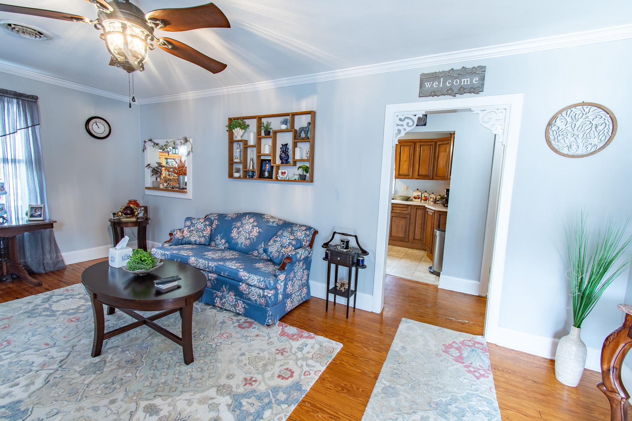 9 Oak Street Cambridge, MD 21613 - Photo 6 of 29 a living room with furniture a rug and a chandelier