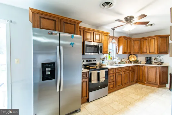 a kitchen with stainless steel appliances granite countertop a refrigerator a stove and a sink