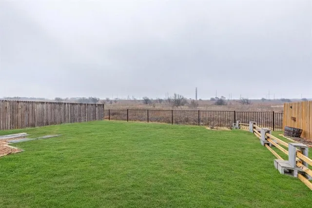 a view of a backyard with wooden fence