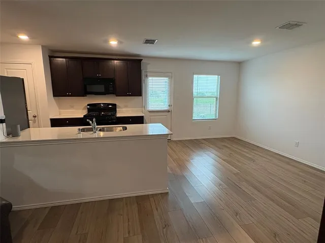 a kitchen with a sink wooden floor and a large window