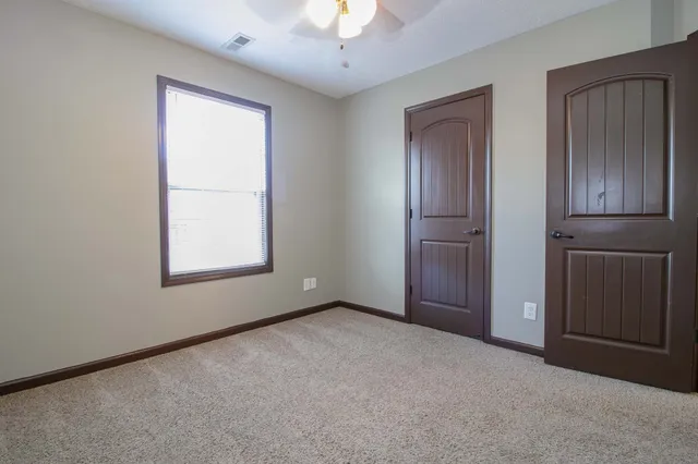 an empty room with windows and closet
