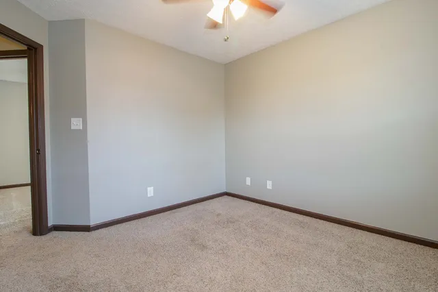 a view of an empty room with a chandelier fan