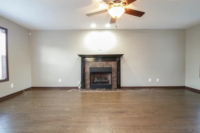 an empty room with a fireplace and fan