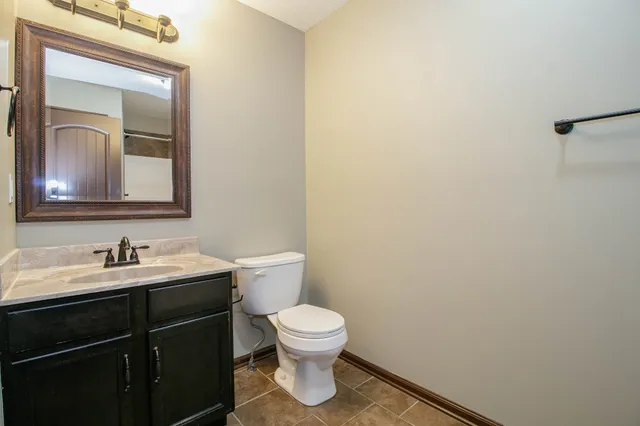 a bathroom with a toilet a sink and mirror