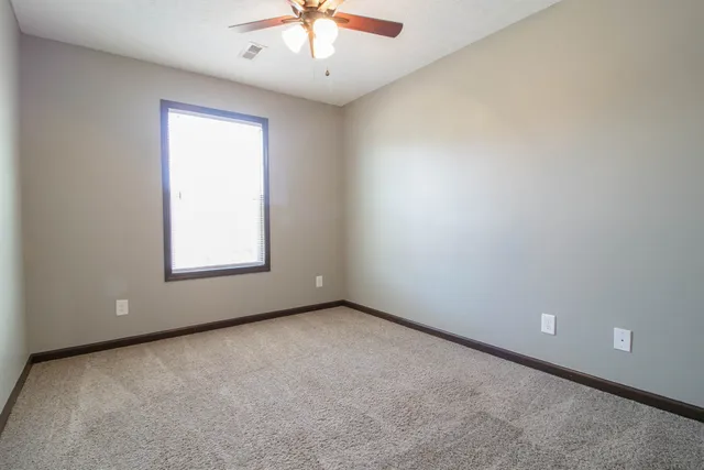 an empty room with a chandelier fan