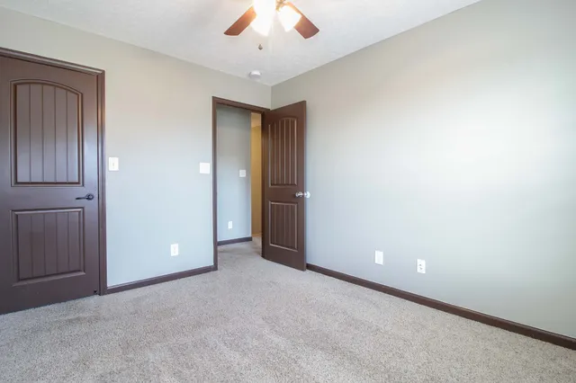 an empty room with a ceiling fan and a window