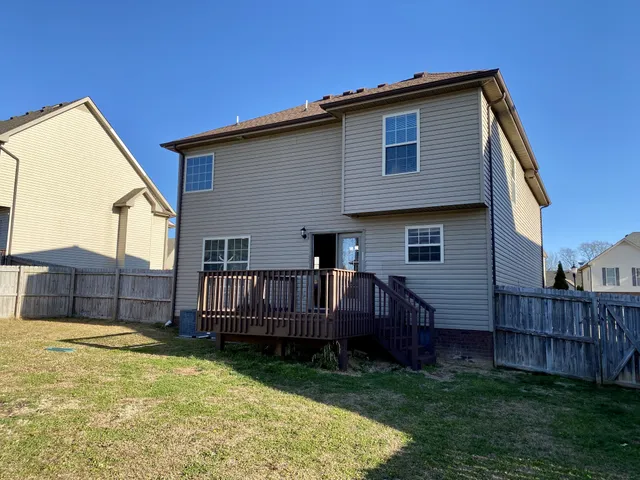 a view of a house with wooden deck and a backyard