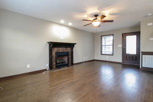 a view of an empty room with a fireplace and a window