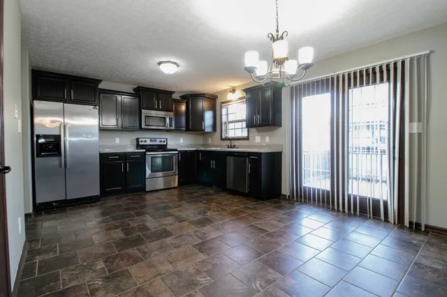 a kitchen with stainless steel appliances granite countertop a refrigerator and a sink