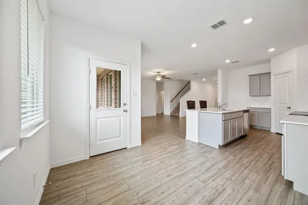 an empty room with wooden floor and window
