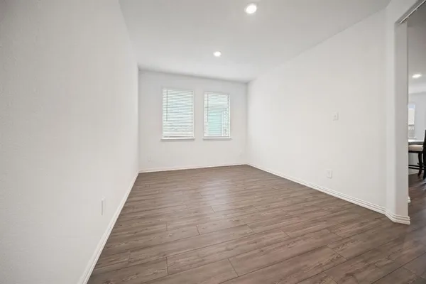 an empty room with windows and fan