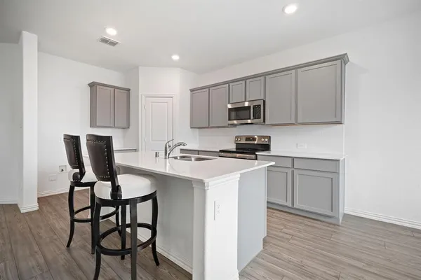 a kitchen with a sink cabinets and wooden floor