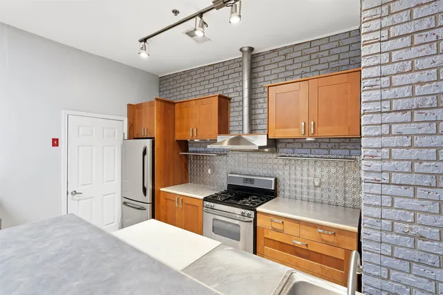 a kitchen with stainless steel appliances a stove sink and refrigerator