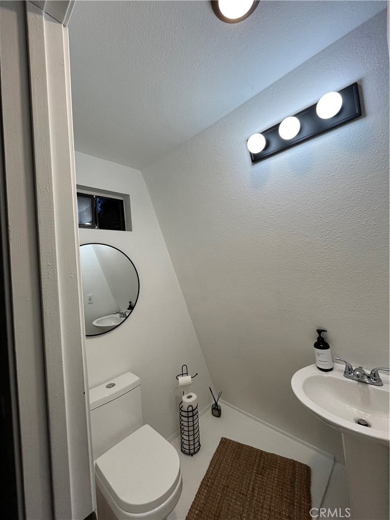 24875 Marion Ridge Drive Idyllwild, CA 92549 - Photo 25 of 47 a bathroom with a toilet a sink and mirror