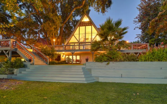 a view of a house with a yard and potted plants