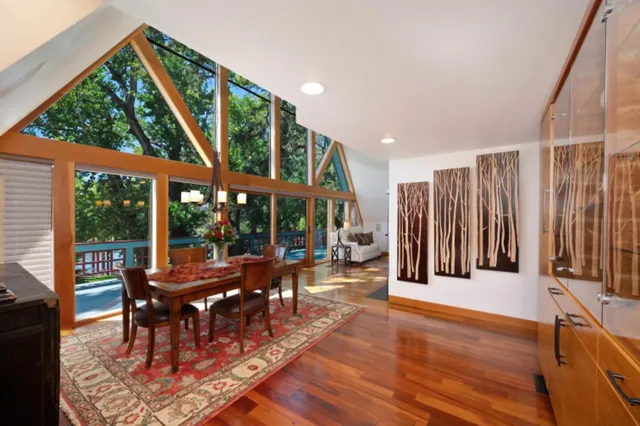 a dining hall with stainless steel appliances granite countertop a sink and dishwasher a stove with wooden floor