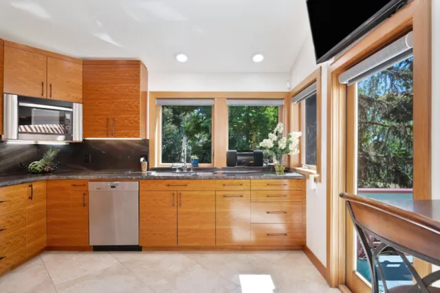 a kitchen with stainless steel appliances a stove a microwave and a shower