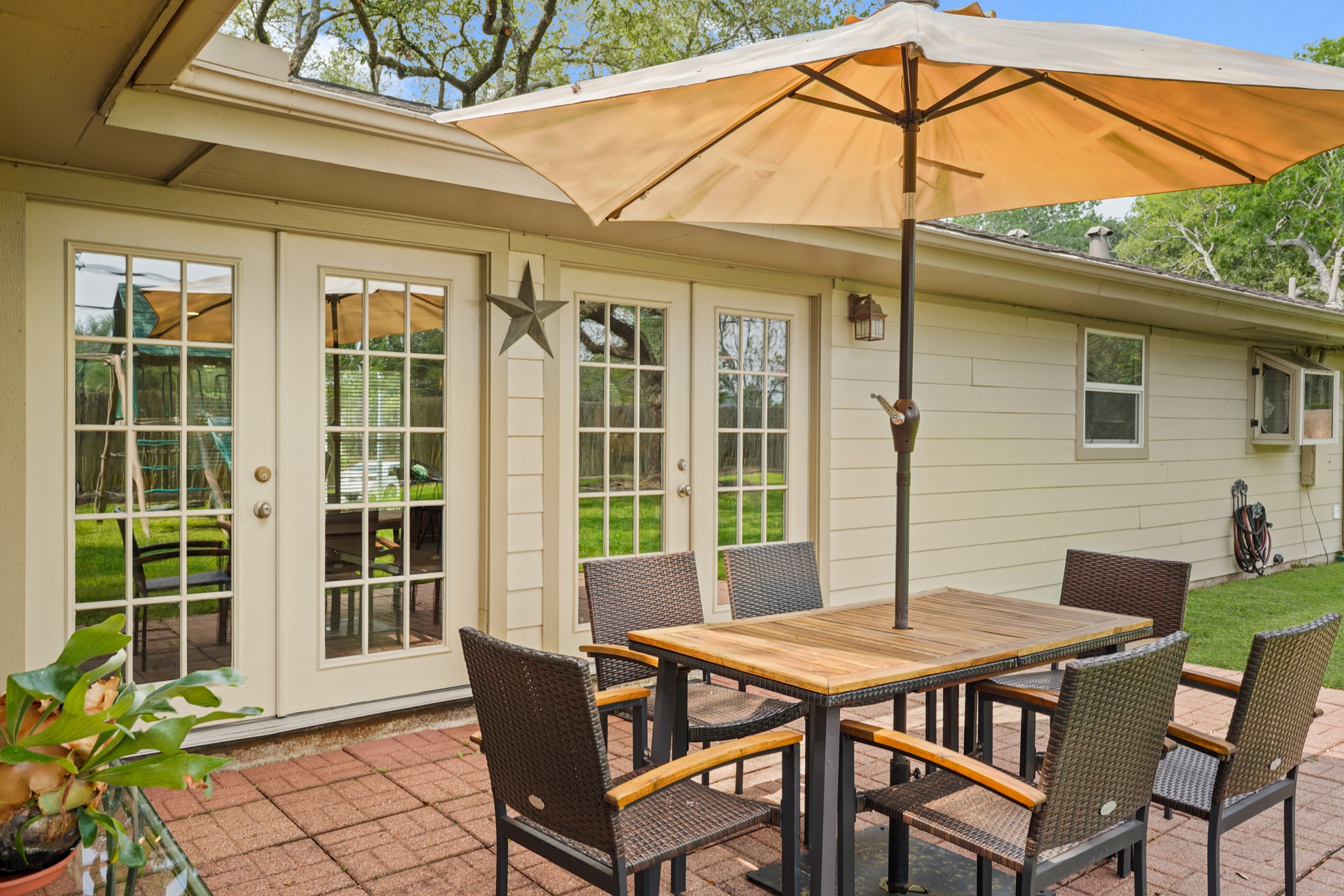 5242 Sanford Road Houston, TX 77035 - Photo 28 of 34 Charming backyard patio featuring a relaxing brick-paved area! French doors open to the house and plenty of lush green grass, perfect for outdoor gatherings.