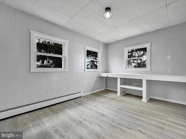 an empty room with windows and furniture