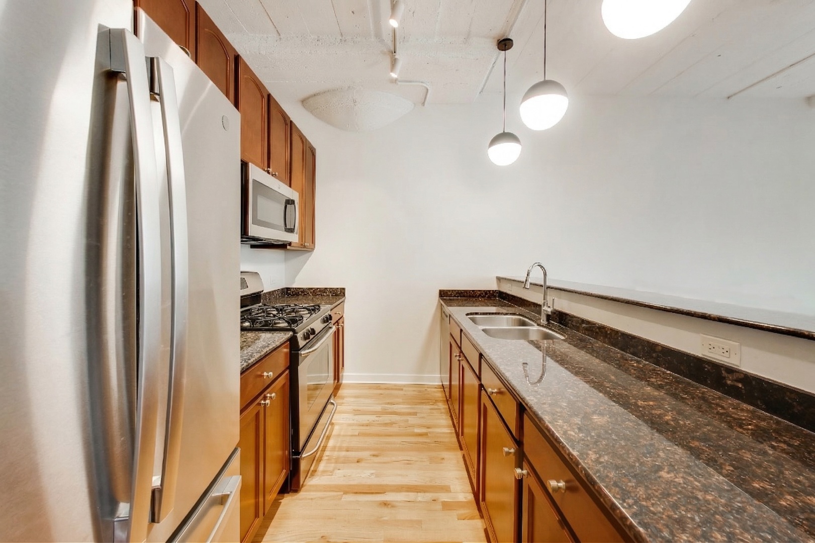 1069 West 14th Place, Unit 228 Chicago, IL 60608 - Photo 9 of 20 a kitchen with a stove and a refrigerator