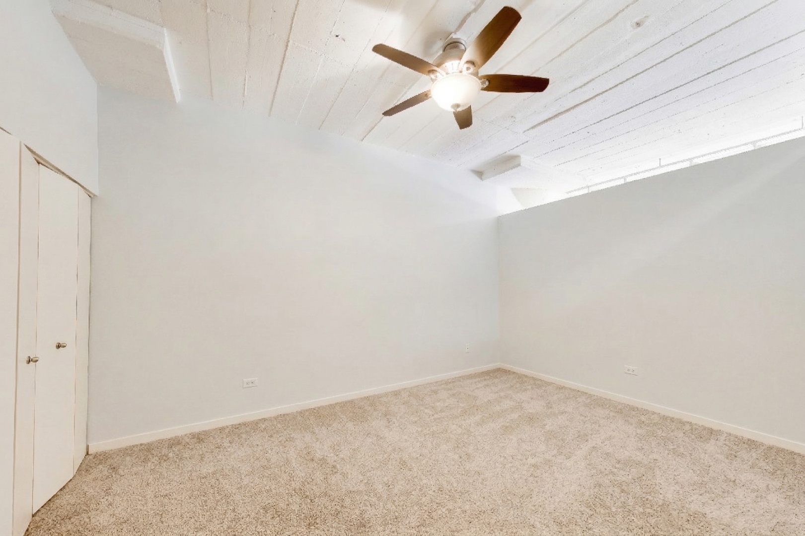 1069 West 14th Place, Unit 228 Chicago, IL 60608 - Photo 10 of 20 an empty room with a chandelier fan and windows