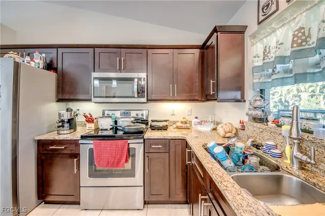 a kitchen with stainless steel appliances granite countertop a sink stove and cabinets