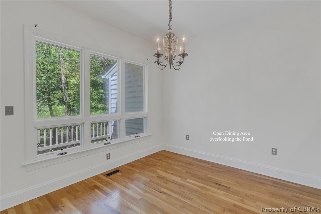 5818 Rivers Landing Terrace, Unit 5818 White Stone, VA 22578 - Photo 14 of 50 Empty room featuring an inviting chandelier and light hardwood / wood-style floors