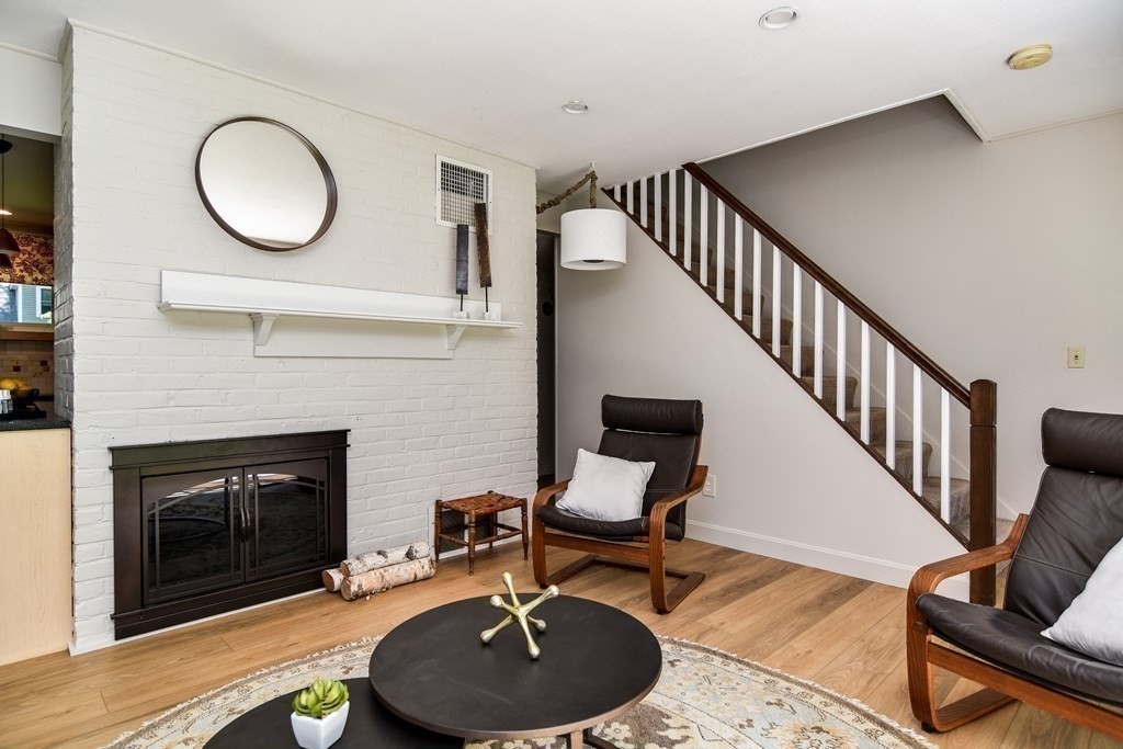 9 Braemore Road Natick, MA 01760 - Photo 14 of 24 a living room with furniture a fireplace and a flat screen tv