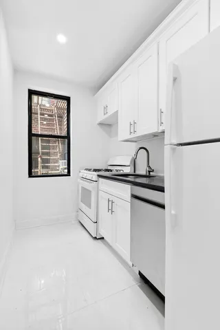 a kitchen with white cabinets and white appliances