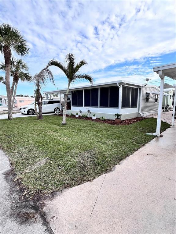2295 North Beach Road, Unit 23 Englewood, FL 34223 - Photo 4 of 19 a view of a house with a garden and trees